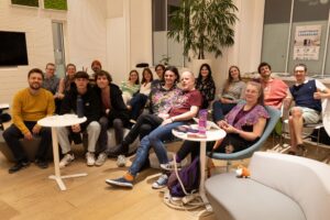 Eine Gruppe von Menschen in einem Raum, alle lächeln in die Kamera.