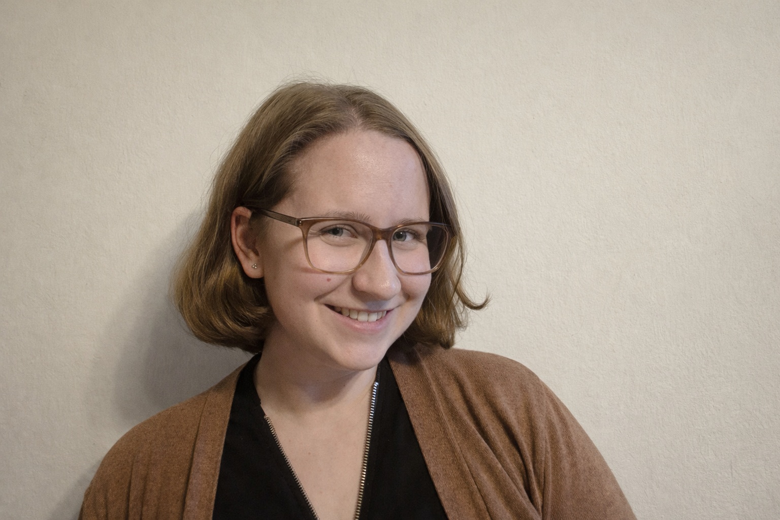 Eine junge Frau, die in die Kamera lächelt.